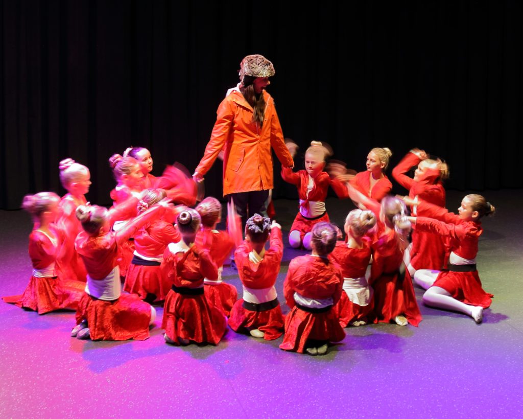 Barn i røde kostymer på scenen