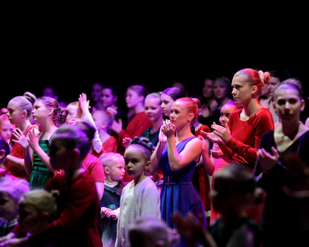 Barn sitter i salen under forestilling